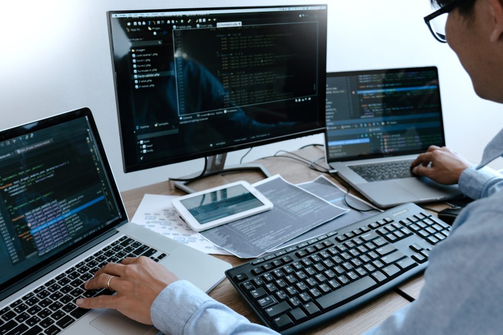 Programmer Typing Code on Desktop Computer